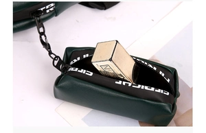 Detail view of a dark green PU leather mini pouch with metal chain and zipper