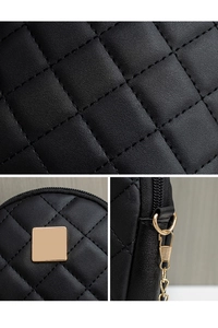 Detail of black quilted phone bag with gold hardware and fine embroidery texture