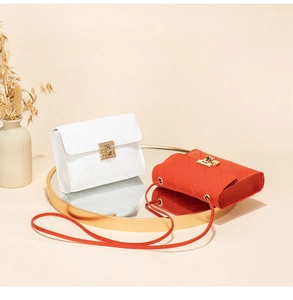 Detailed view of quilted faux leather crossbody bags in white and orange with gold twist locks