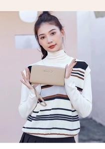 Close-up of a khaki long leather clutch bag with a wristlet strap and golden metal logo