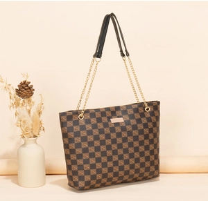 Détail du sac cabas à motif damier avec bandoulière en chaîne dorée et cuir