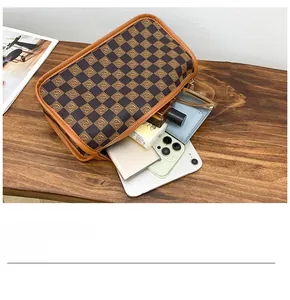 Top view of a checkered pattern toiletry bag organized with a smartphone and accessories