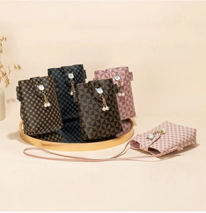 Detail of printed crossbody phone bag with cat-shaped clasp and pearl tassel decor