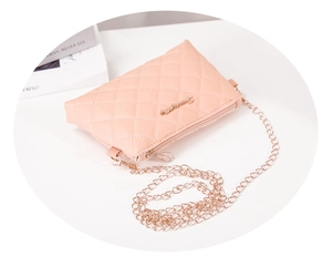 Detailed close-up of pink quilted crossbody bag with metal chain strap and floral logo
