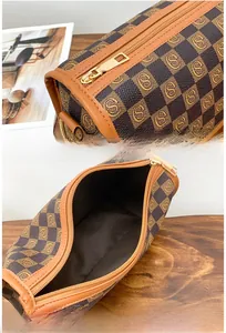 Macro shot of the brown checkered cylinder bag with gold zipper and internal storage
