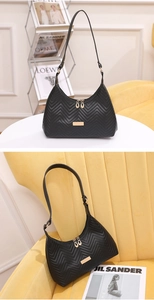 Detail of black V-quilted faux leather shoulder bag with gold zipper and metal logo plate