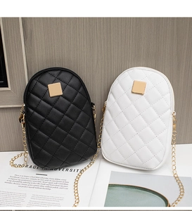 Detail of quilted mini crossbody phone bags in black and white with gold chain straps
