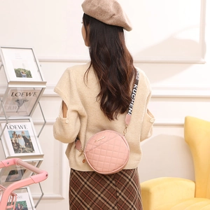 Pink quilted circular crossbody bag for women with a stylish wide patterned strap