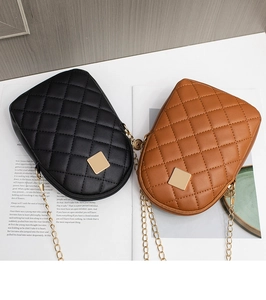 Detail view of quilted chain small crossbody bags in black and brown with gold hardware
