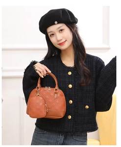 Close-up of brown quilted handbag with mini accessory pouch and golden flower zipper detail