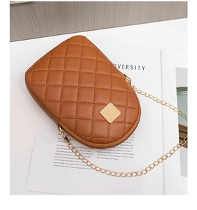 Close-up of brown quilted phone bag with gold chain strap and square metal plaque