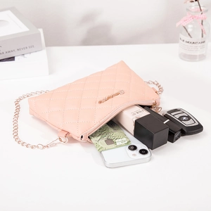Pink quilted crossbody bag with rose gold chain strap shown with daily essentials