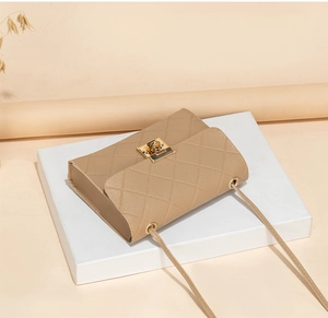 Detail view of beige quilted faux leather bag with elegant gold metal twist lock