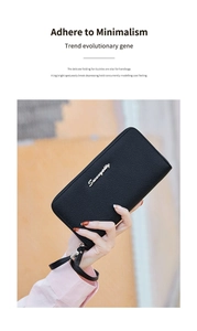 Close-up of black lychee grain leather wallet with metal logo and wrist strap
