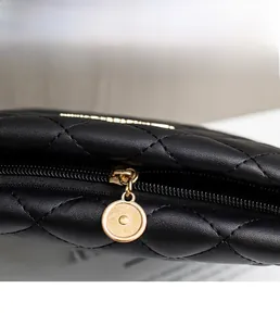 Detailed close-up of quilted black leather bag with premium gold circular metal zipper pull