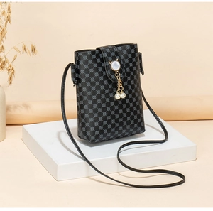 Detail of black mini crossbody bag with cat-ear metal buckle and pearl tassel accents