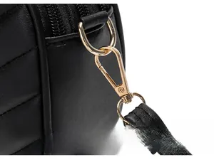 Detail of gold metal hook and black pebbled leather strap on quilted camera bag