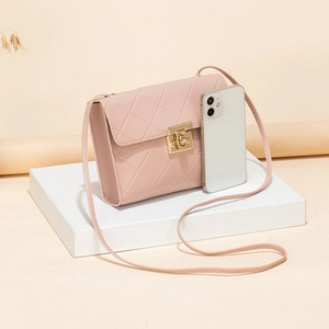 Pink quilted shoulder bag with gold twist lock and leather strap, shown with smartphone for scale