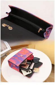 Detailed interior of snakeskin gradient bag showing storage of perfume and cosmetics