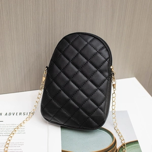Black quilted crossbody cell phone bag with gold chain strap on a white table display