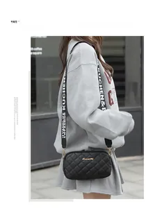 Detail of quilted crossbody bag with stylish black and white lettered wide strap