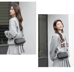 Detail of black quilted camera bag with stylish letter-print wide shoulder strap