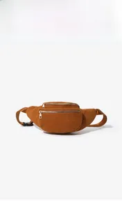 Close-up of brown corduroy waist bag showing double-layered zippers and texture