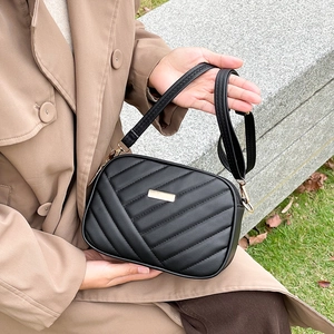 Elegant black quilted crossbody bag with gold hardware and V-shaped stitching detail