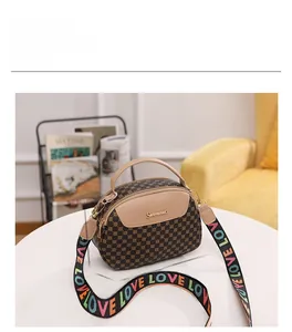 Vue détaillée du petit sac Boston imprimé avec bandoulière LOVE colorée sur table