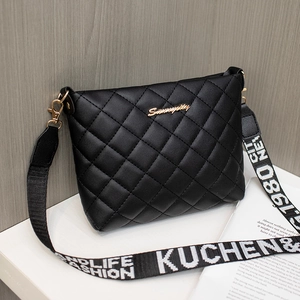 Quilted black bucket bag with gold hardware and wide letter-printed shoulder strap