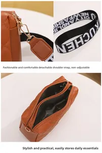 Detail of brown quilted crossbody bag showing dual zippers and detachable strap