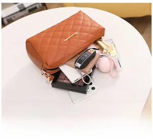 Brown quilted leather cosmetic bag interior capacity showing phone and makeup items