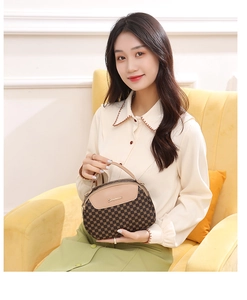 Détail d'un mini sac à main imprimé pour femme avec rabat en cuir et logo métallique