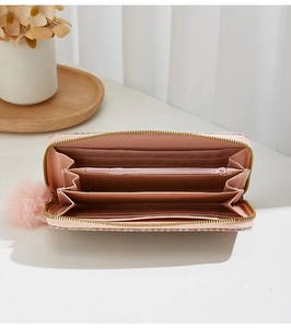 Détail du portefeuille rose à carreaux montrant les fentes pour cartes et le pompon