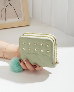 Détail d'un portefeuille vert clair à double fermeture éclair avec rivets et matelassage