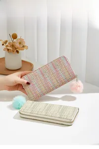 Texture tissée détaillée et pendentif pompon coloré sur un long portefeuille tissé