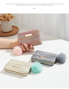 Detailed view of woven texture small purses in pink, blue, and beige with fuzzy pompom charms