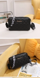 Detail of black quilted crossbody bag with golden logo and wide embroidered strap
