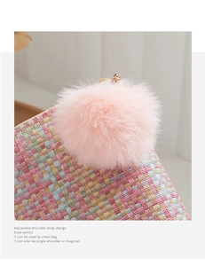 Detail of colorful woven bag featuring a pink faux fur pompom and adjustable strap