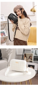 Detail of quilted crossbody camera bag featuring a wide fabric strap and golden metal hardware