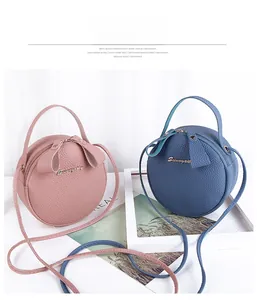 Close-up of pink and blue round lychee pattern leather bags with metallic logo