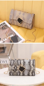Detail of snake print texture and gold chain strap on stylish gradient crossbody bag