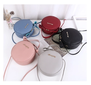 Detail view of round crossbody bags in multiple colors with lychee grain PU leather