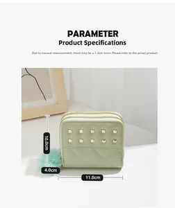 Détail du portefeuille en similicuir menthe avec rivets dorés et pompon en peluche