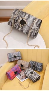 Macro detail of snakeskin pattern texture and metallic magnetic clasp on gradient bag