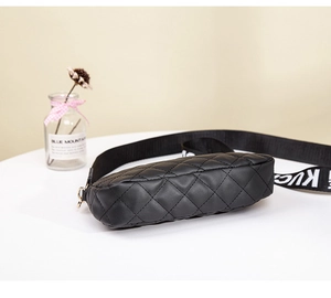 Detail of black quilted leather camera bag with stylish wide woven letter strap