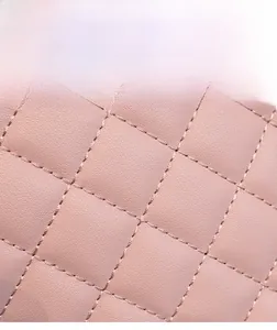 Close-up of pink quilted faux leather material with delicate diamond stitch texture