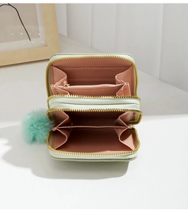 Détail du mini portefeuille en cuir vert menthe avec double fermeture éclair et pompon
