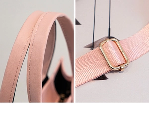 Detail view of pink leather handle stitching and adjustable fabric strap with gold buckle