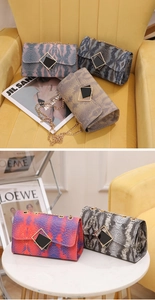 Detailed shot of snakeskin texture women handbag with gold diamond clasp and chain strap